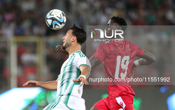 Rami Bensebaini (L) of Algeria in action with Nlavo Asue Luis Miguel of Guinea during the qualification match for the African Cup of Nations...