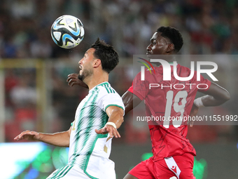 Rami Bensebaini (L) of Algeria in action with Nlavo Asue Luis Miguel of Guinea during the qualification match for the African Cup of Nations...