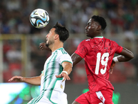 Rami Bensebaini (L) of Algeria in action with Nlavo Asue Luis Miguel of Guinea during the qualification match for the African Cup of Nations...