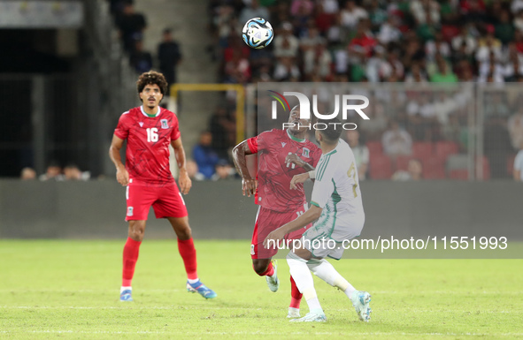 Riyad Karim Mahrez of Algeria competes with Basilio Ndong Owono of Guinea during the qualification match for the African Cup of Nations (CAN...