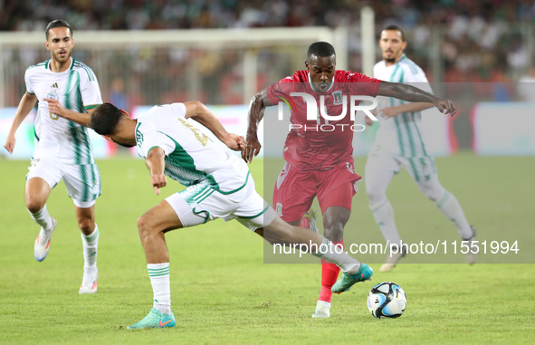 Mohamed Amine Tougai of Algeria competes with Basilio Ndong Owono of Equatorial Guinea during the qualification match for the African Cup of...