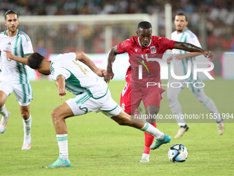 Mohamed Amine Tougai of Algeria competes with Basilio Ndong Owono of Equatorial Guinea during the qualification match for the African Cup of...