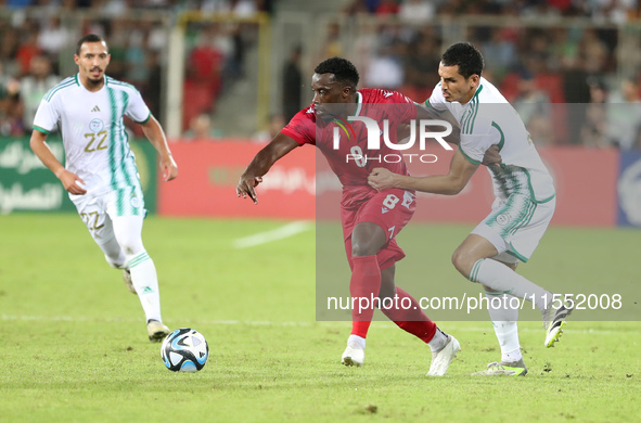 Aissa Mandi (R) of Algeria in action with Jannick Buyla Sam of Equatorial Guinea during the football match of the qualification of the Afric...