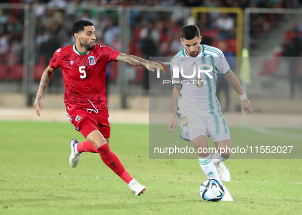 Houssem Eddine Aouar (right) of Algeria in action with Omar Mascarell Gonzales of Guinea during the football match of the qualification of t...