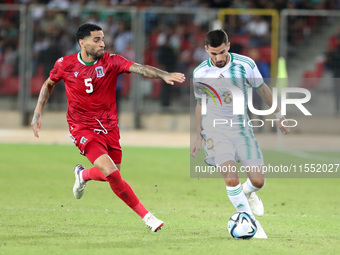 Houssem Eddine Aouar (right) of Algeria in action with Omar Mascarell Gonzales of Guinea during the football match of the qualification of t...