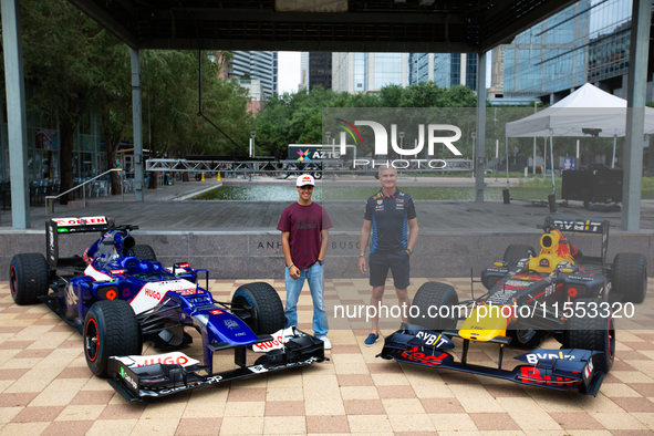 Former Formula 1 driver David Coulthard and Red Bull Junior Driver Arvid Lindblad pose in front of two championship-winning F1 cars, an RB7...