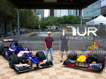 Former Formula 1 driver David Coulthard and Red Bull Junior Driver Arvid Lindblad pose in front of two championship-winning F1 cars, an RB7...