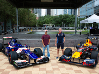 Former Formula 1 driver David Coulthard and Red Bull Junior Driver Arvid Lindblad pose in front of two championship-winning F1 cars, an RB7...