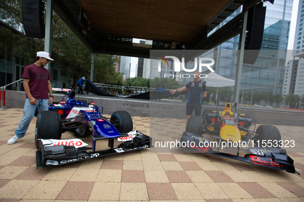 Former Formula 1 driver David Coulthard and Red Bull Junior Driver Arvid Lindblad stand next to two championship-winning F1 cars, an RB7 and...