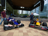 Former Formula 1 driver David Coulthard and Red Bull Junior Driver Arvid Lindblad stand next to two championship-winning F1 cars, an RB7 and...