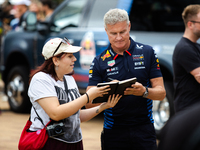 Former Formula 1 driver David Coulthard signs something for a fan at a private preview event for Red Bull's Houston Showrun in Houston, Texa...