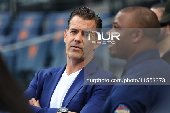 Former Mets general manager Brodie Van Wagenen stands on the field chatting with Rajai Davis during batting practice before the baseball gam...