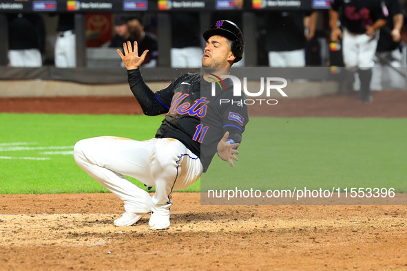 New York Mets' Jose Iglesias #11 flips himself up after scoring during the sixth inning of the baseball game against the Cincinnati Reds at...