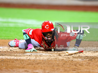 Elly De La Cruz #44 of the Cincinnati Reds hits the ground after avoiding a pitch during the ninth inning of the baseball game against the N...