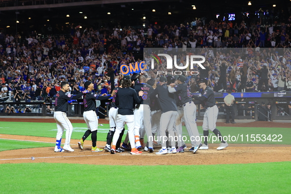 New York Mets' Mark Vientos #27 is mobbed by teammates at home plate after a 10th inning game-winning home run to give the Mets a 6-4 victor...