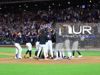 New York Mets' Mark Vientos #27 is mobbed by teammates at home plate after a 10th inning game-winning home run to give the Mets a 6-4 victor...