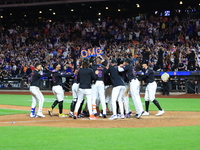 New York Mets' Mark Vientos #27 is mobbed by teammates at home plate after a 10th inning game-winning home run to give the Mets a 6-4 victor...