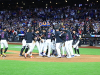 New York Mets' Mark Vientos #27 is mobbed by teammates at home plate after a 10th inning game-winning home run to give the Mets a 6-4 victor...