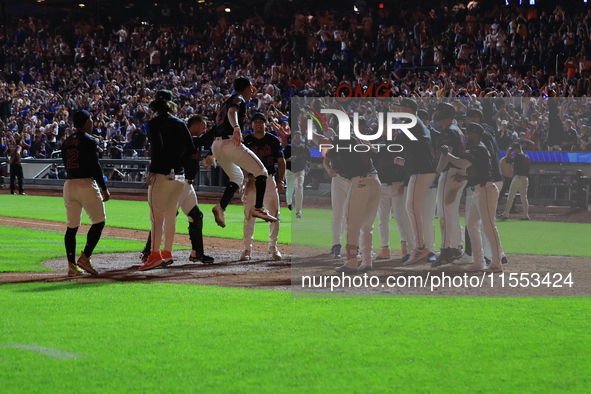 New York Mets' Mark Vientos #27 is mobbed by teammates at home plate after a 10th inning game-winning home run to give the Mets a 6-4 victor...