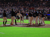 New York Mets' Mark Vientos #27 is mobbed by teammates at home plate after a 10th inning game-winning home run to give the Mets a 6-4 victor...