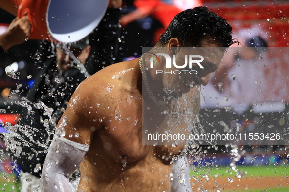 New York Mets' Mark Vientos #27 receives a Gatorade and water bath from teammates after his 10th inning game-winning home run lifts the Mets...