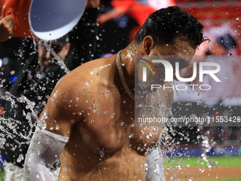 New York Mets' Mark Vientos #27 receives a Gatorade and water bath from teammates after his 10th inning game-winning home run lifts the Mets...