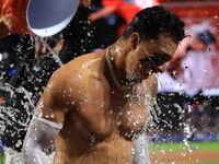 New York Mets' Mark Vientos #27 receives a Gatorade and water bath from teammates after his 10th inning game-winning home run lifts the Mets...