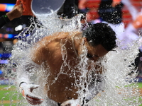 New York Mets' Mark Vientos #27 receives a Gatorade and water bath from teammates after his 10th inning game-winning home run lifts the Mets...