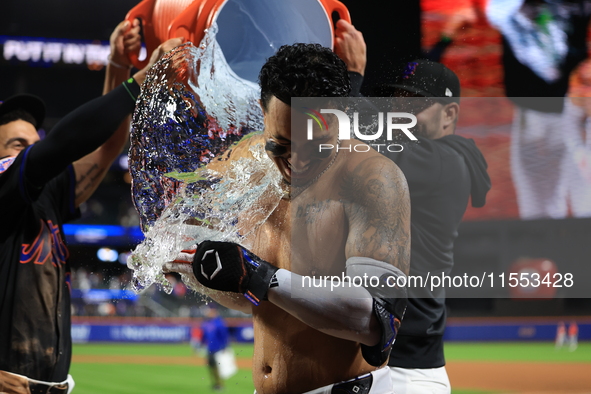 New York Mets' Mark Vientos #27 receives a Gatorade and water bath from teammates after his 10th inning game-winning home run lifts the Mets...