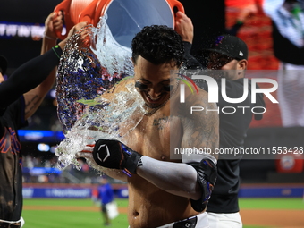 New York Mets' Mark Vientos #27 receives a Gatorade and water bath from teammates after his 10th inning game-winning home run lifts the Mets...