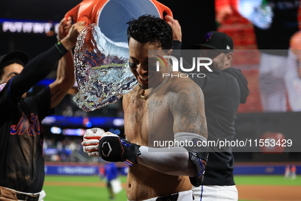 New York Mets' Mark Vientos #27 receives a Gatorade and water bath from teammates after his 10th inning game-winning home run lifts the Mets...