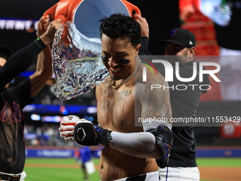 New York Mets' Mark Vientos #27 receives a Gatorade and water bath from teammates after his 10th inning game-winning home run lifts the Mets...