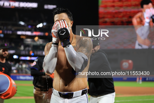 New York Mets' Mark Vientos #27 receives a Gatorade and water bath from teammates after his 10th inning game-winning home run lifts the Mets...