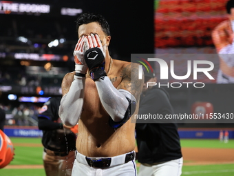 New York Mets' Mark Vientos #27 receives a Gatorade and water bath from teammates after his 10th inning game-winning home run lifts the Mets...