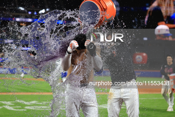 New York Mets' Mark Vientos #27 receives a Gatorade and water bath from teammates after his 10th inning game-winning home run lifts the Mets...