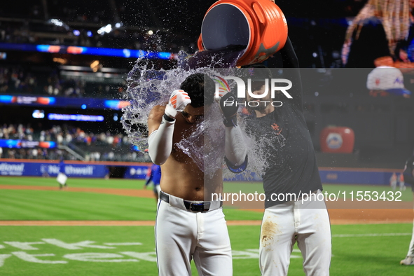 New York Mets' Mark Vientos #27 receives a Gatorade and water bath from teammates after his 10th inning game-winning home run lifts the Mets...