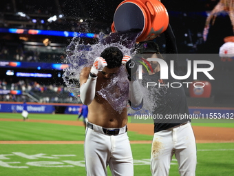 New York Mets' Mark Vientos #27 receives a Gatorade and water bath from teammates after his 10th inning game-winning home run lifts the Mets...