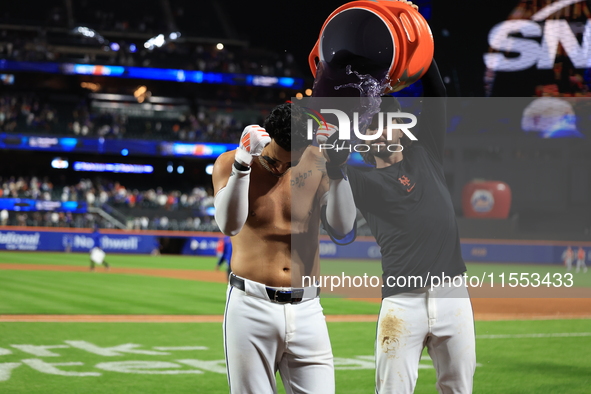 New York Mets' Mark Vientos #27 receives a Gatorade and water bath from teammates after his 10th inning game-winning home run lifts the Mets...