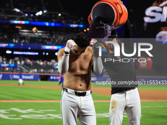 New York Mets' Mark Vientos #27 receives a Gatorade and water bath from teammates after his 10th inning game-winning home run lifts the Mets...