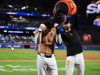 New York Mets' Mark Vientos #27 receives a Gatorade and water bath from teammates after his 10th inning game-winning home run lifts the Mets...