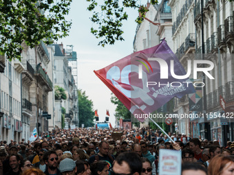 People march holding a flag of 'La France Insoumise' during a protest after the appointment of a right-wing prime minister two days ago foll...