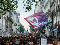 People march holding a flag of 'La France Insoumise' during a protest after the appointment of a right-wing prime minister two days ago foll...