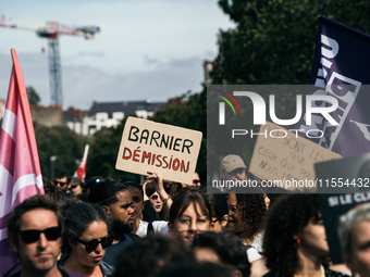 A protestor holds a placard reading, 'Macron destitution' as he takes part in a demonstration after the appointment of a right-wing prime mi...