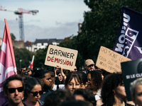 A protestor holds a placard reading, 'Macron destitution' as he takes part in a demonstration after the appointment of a right-wing prime mi...