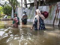 Women walk through waist-deep flood water in a village of Chaumuhni Municipality in Noakhali District of Chittagong Division in Noakhali, Ch...