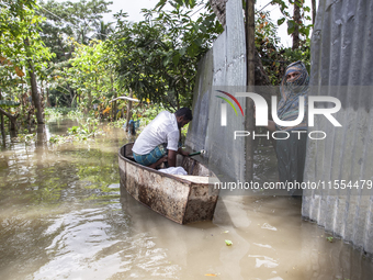 A man prepares his boat to go to the market in knee-deep flooded water in a village in Chaumuhni Municipality of Noakhali District, Chittago...