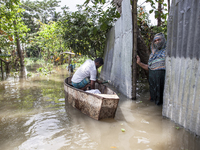 A man prepares his boat to go to the market in knee-deep flooded water in a village in Chaumuhni Municipality of Noakhali District, Chittago...