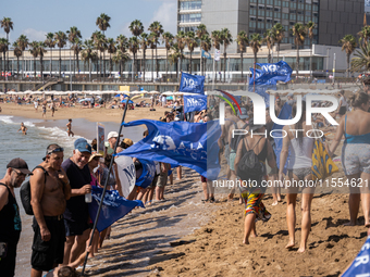 Dozens of Barcelona residents protest on the Somorrostro beach in the Barceloneta neighborhood against the America's Cup 2024, in Barcelona,...