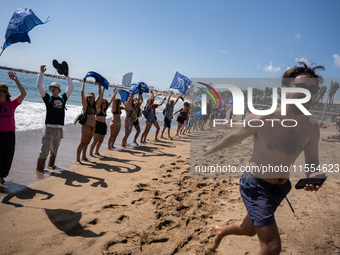 Dozens of Barcelona residents protest on the Somorrostro beach in the Barceloneta neighborhood against the America's Cup 2024, in Barcelona,...