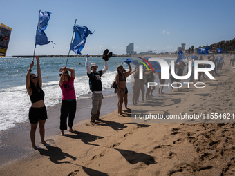 Dozens of Barcelona residents protest on the Somorrostro beach in the Barceloneta neighborhood against the America's Cup 2024, in Barcelona,...